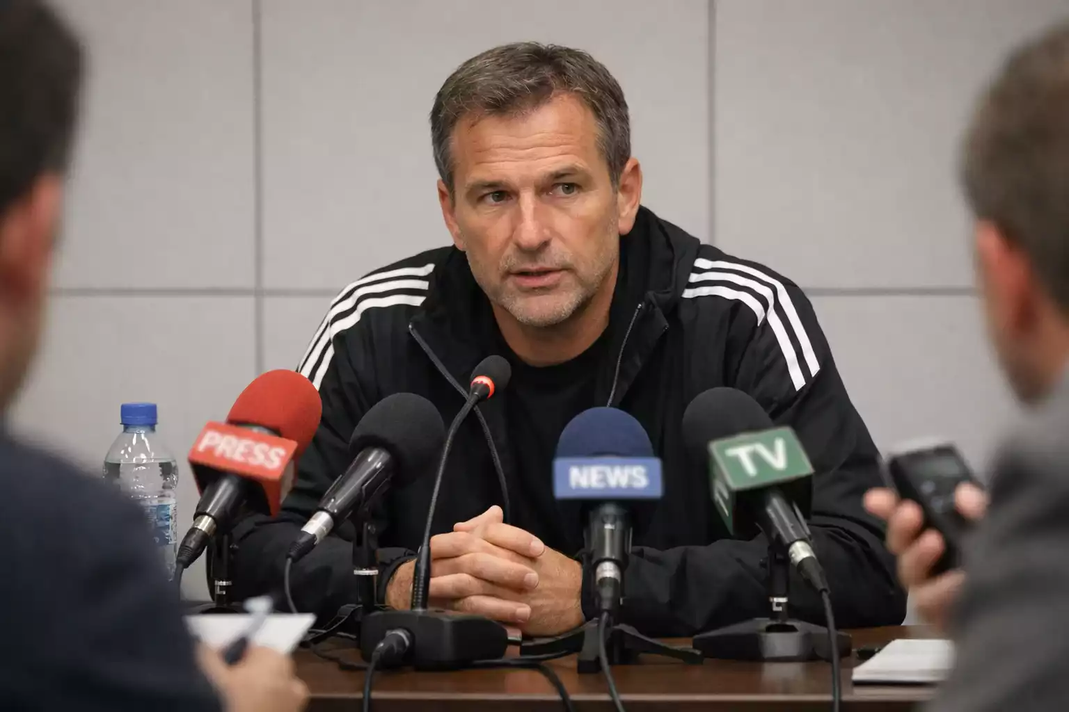 Fußballtrainer spricht auf der Pressekonferenz vor dem Spieltag